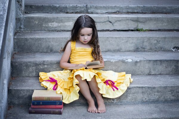 Ragazza con i libri si siede sulle scale