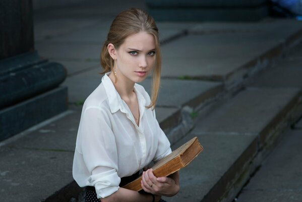 A serious girl with a book in her hands
