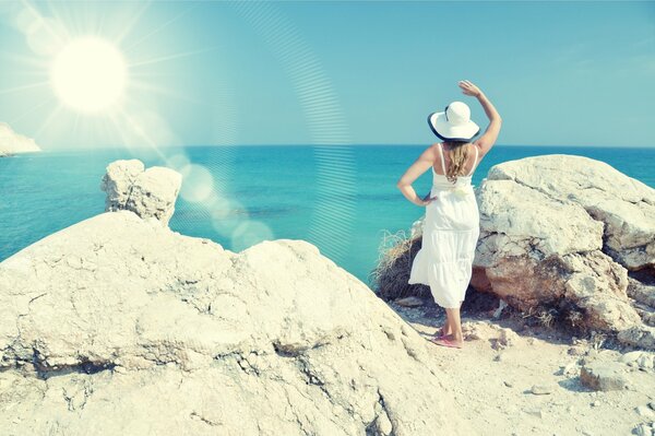 Silhouette di una ragazza in un cappello bianco su uno sfondo di mare