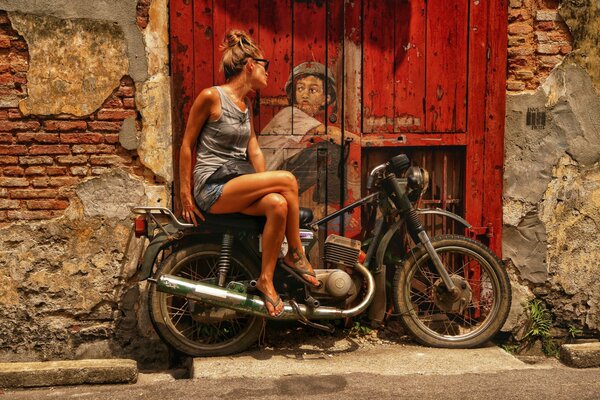 Ville d art sur la porte. la fille sur la moto
