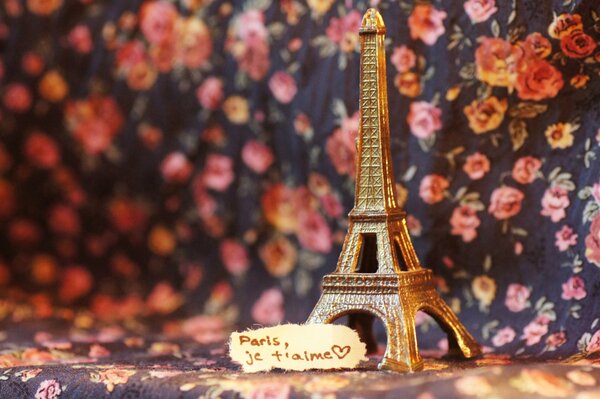 A statuette of the Eiffel Tower on a floral scarf