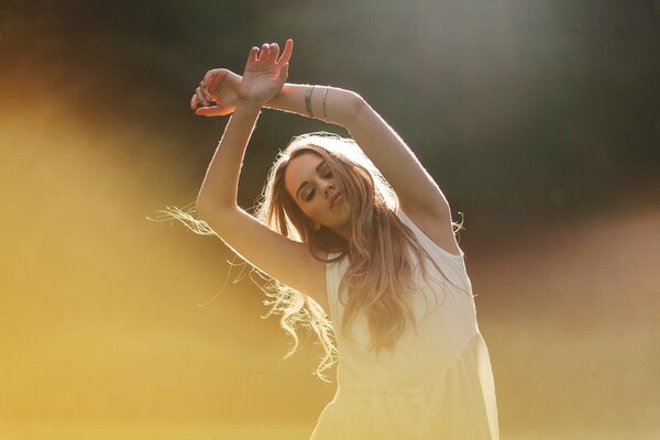 Blonde girl dancing with her hands up