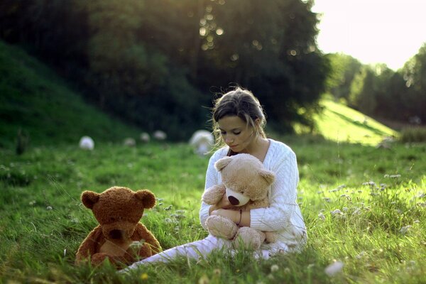 Chica triste se sienta con juguetes en el campo