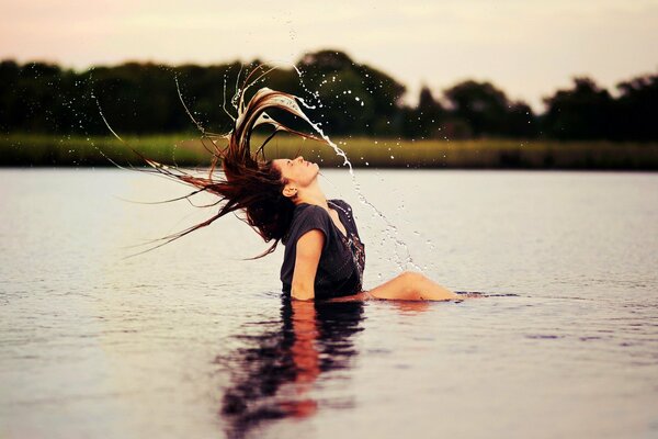 Morena en el lago agitando su cabello