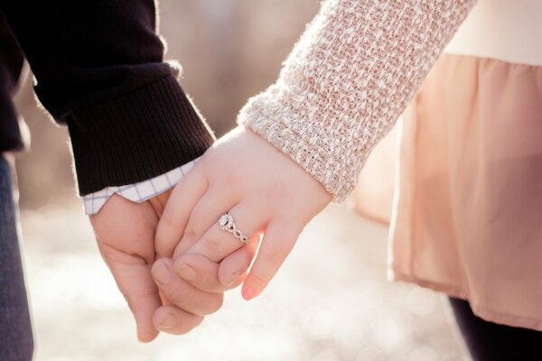 The hands of a guy and a girl are held with love