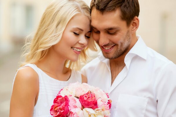 Couple heureux avec des fleurs dans la rue