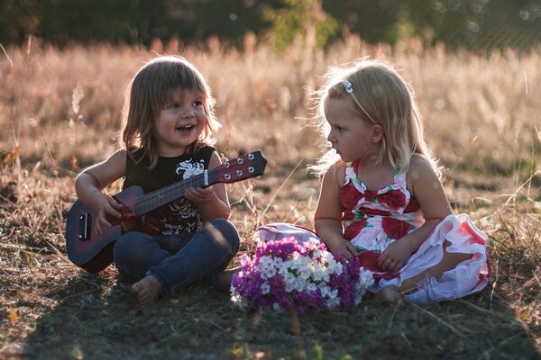 The boy plays the guitar and sings for the girl