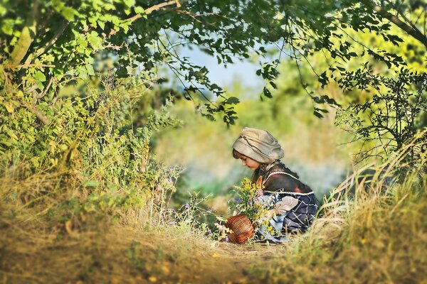 Dziewczyna latem na łonie natury z koszem kwiatów