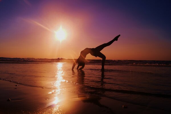 Yoga en la playa. Puesta de sol en el mar