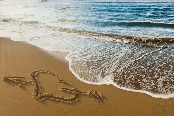 Iscrizione a forma di cuore in riva al mare