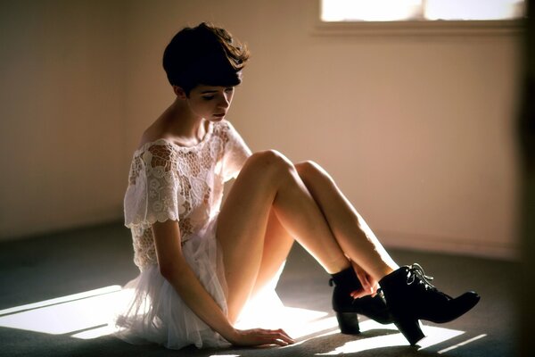 The girl is sitting on the floor in the room