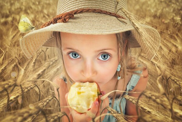 Kind isst einen Apfel im Feld