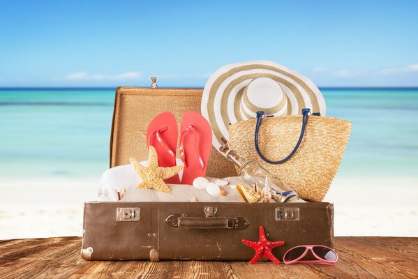 Valigia del viaggiatore sulla spiaggia soleggiata