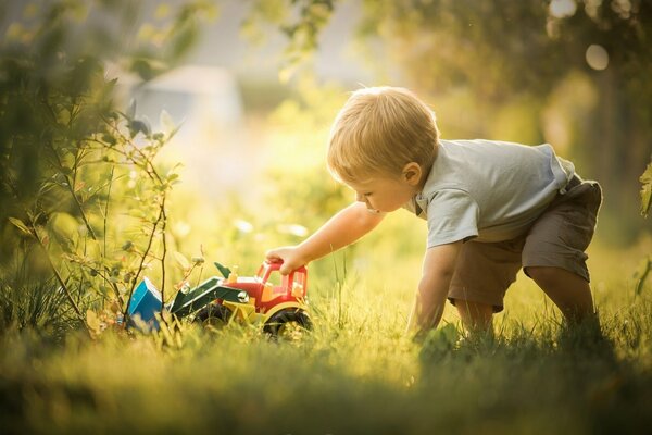 Junge spielt mit einer Schreibmaschine im Gras