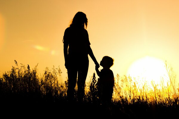 Mädchen mit Jungen im Feld bei Sonnenuntergang