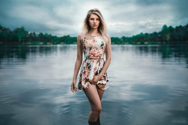 A girl alone on the shore of a lake