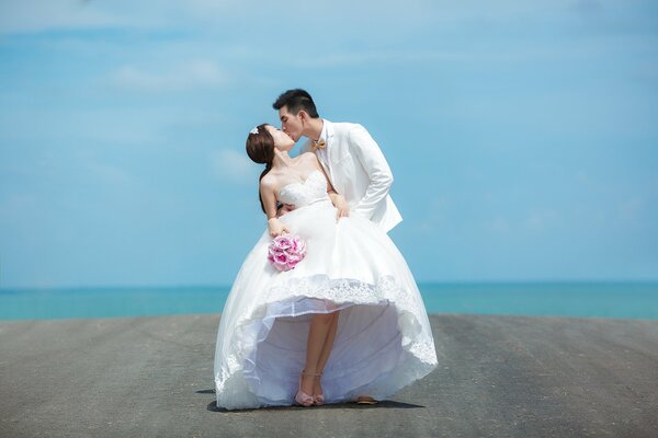 The bride and groom on the background of the sea horizon