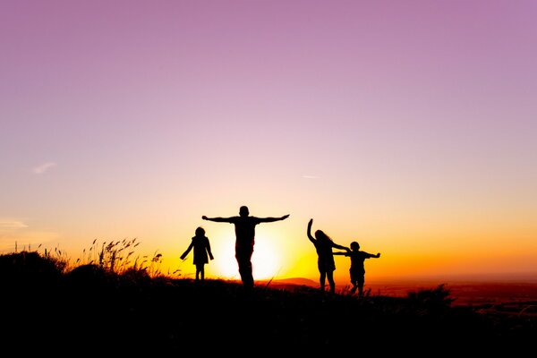 Silhouettes of people against the sunset