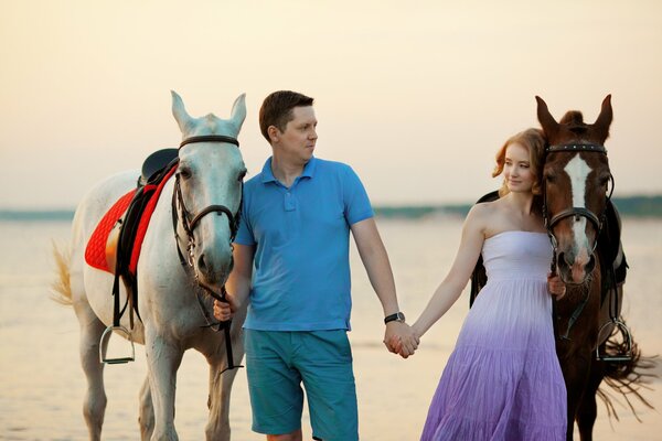Guy, girl and horses at sea