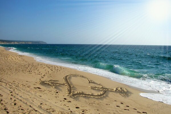 Disegno del cuore sulla sabbia del mare