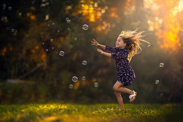 Ragazza che gioca con le bolle colorate