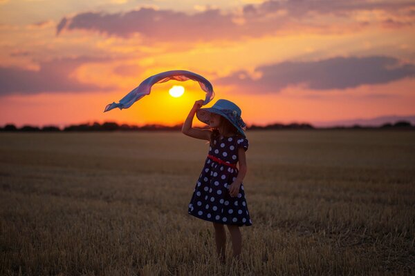 Niña y sol al atardecer en el campo