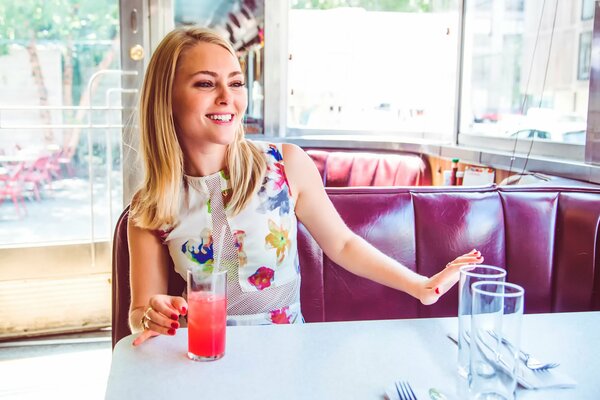 A un tavolo in un bar bere succo di fragola bionda