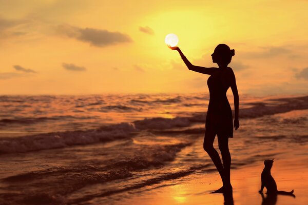 El sol en la palma de la mano de una chica en la orilla