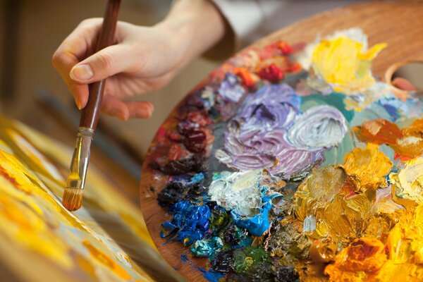 Paleta y pincel en manos del artista