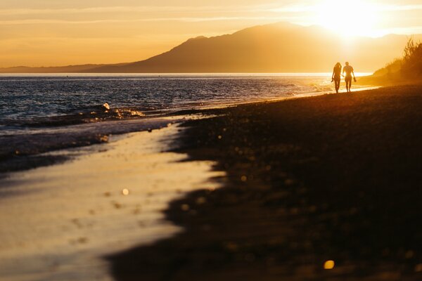 Two lovers meet the sunset on the beach