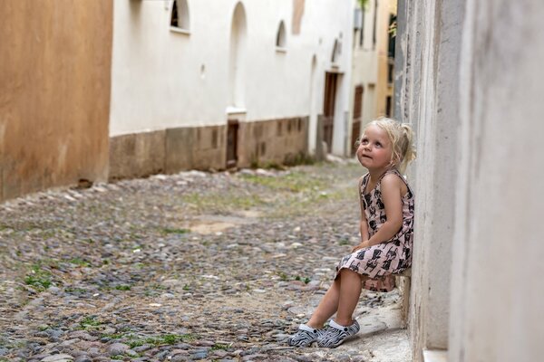 Una niña pensativa se apoya en la pared