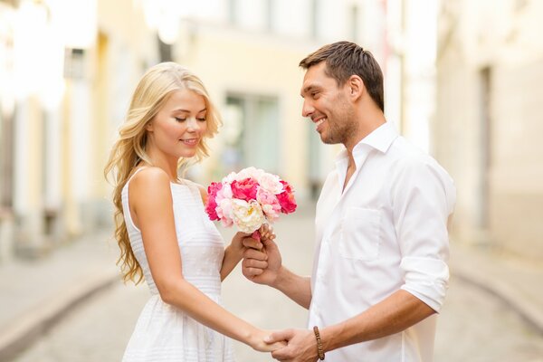 The guy gives the girl a bouquet of flowers