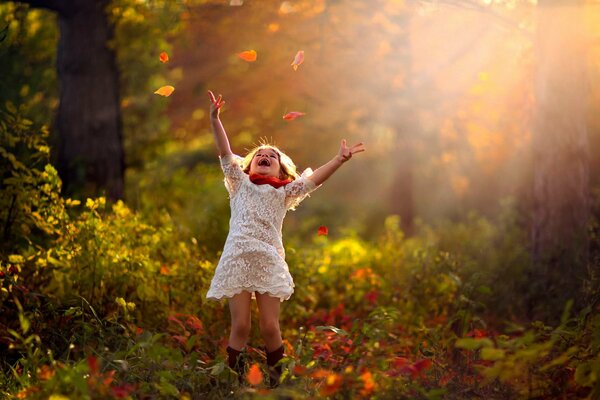 A joyful child in the autumn in the forest