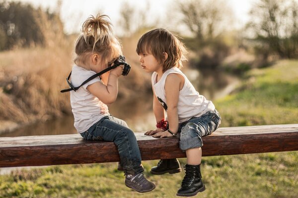 A little girl takes pictures of a friend