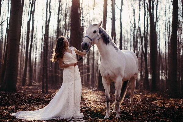 Mädchen im weißen Kleid mit weißem Pferd