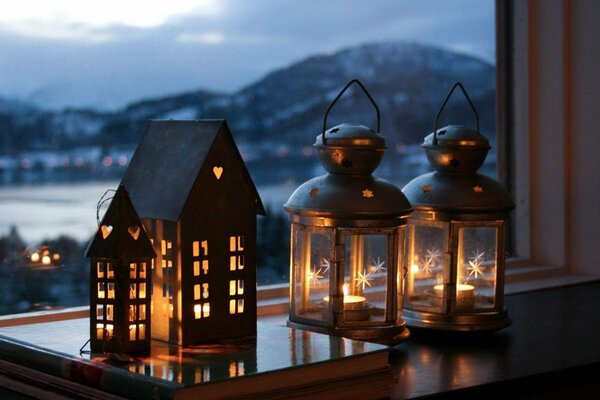 Candelabros de año nuevo en la ventana con vistas a la montaña
