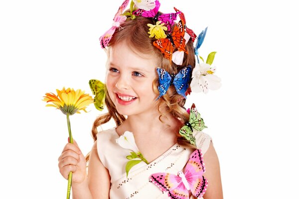 A lovely girl with butterflies in her hair holds a flower