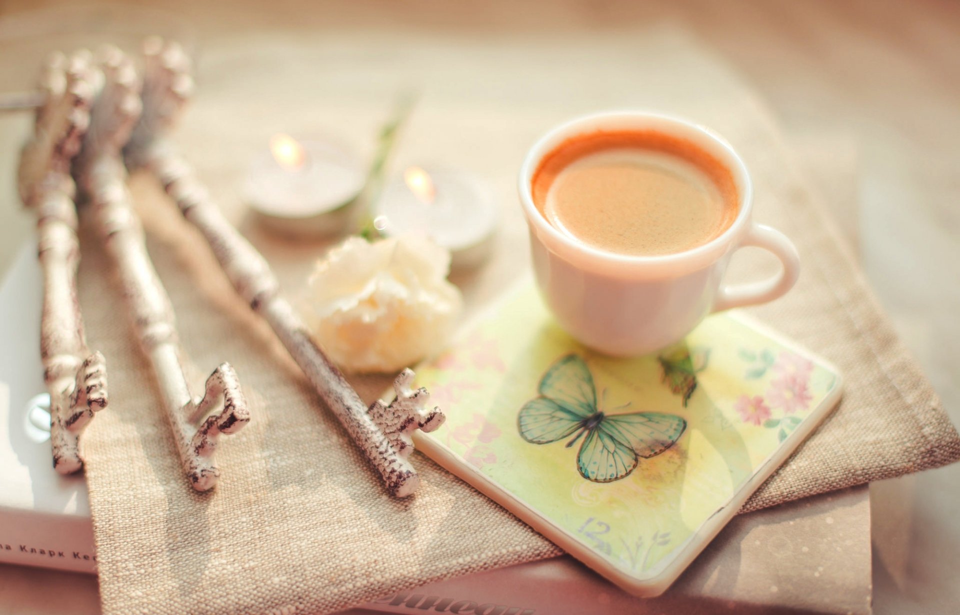 tazza di caffè cappuccino libro chiavi stand fiore candele