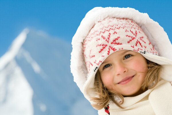 A girl in a hat on the background of mountains