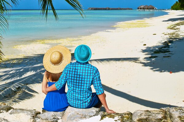 Couple d amoureux dans les chapeaux sur la plage