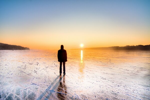 Un hombre en patines admira la puesta de sol