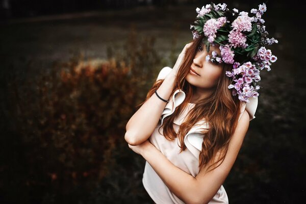 Chica con una corona sobre un fondo oscuro de la naturaleza