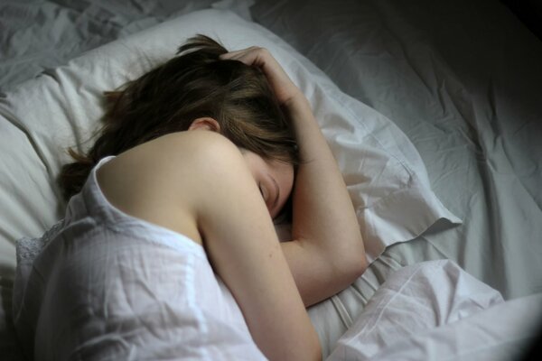 Chica durmiendo en una cama blanca