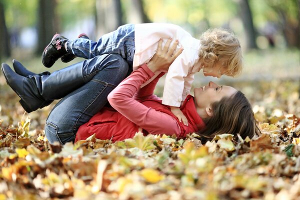 Ragazza con bambino che gioca nel fogliame