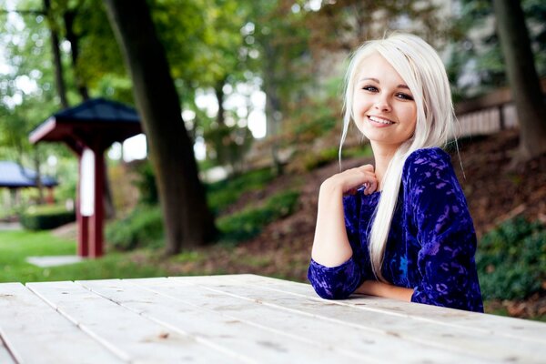 Blonde girl with a smile at the table