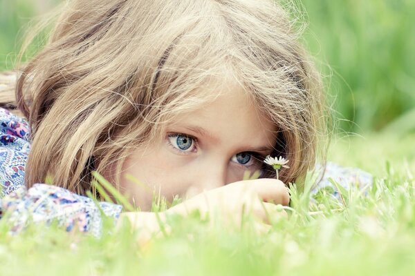 Happy little girl with a daisy