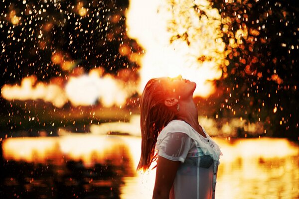 Chica disfruta de la lluvia al atardecer