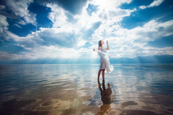 Chica en el mar. Agua clara. La chica camina sobre el agua. Foto misteriosa