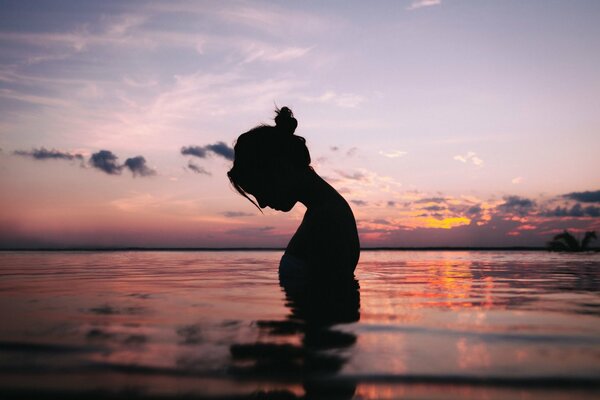 Silhouette of a peaceful girl in a pond