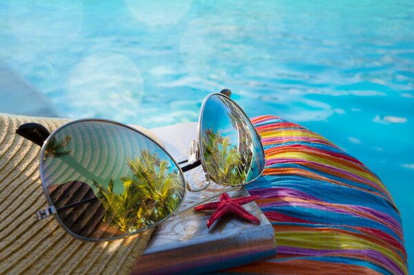 Gafas de sol y estrella junto a la piscina